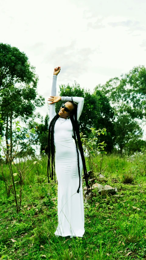 an african woman with dreadlocks is in the grass