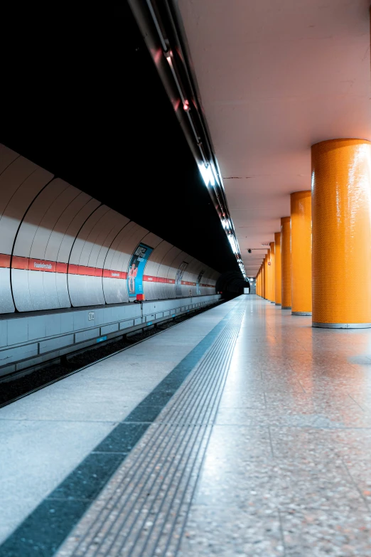 a subway station has an orange and white line