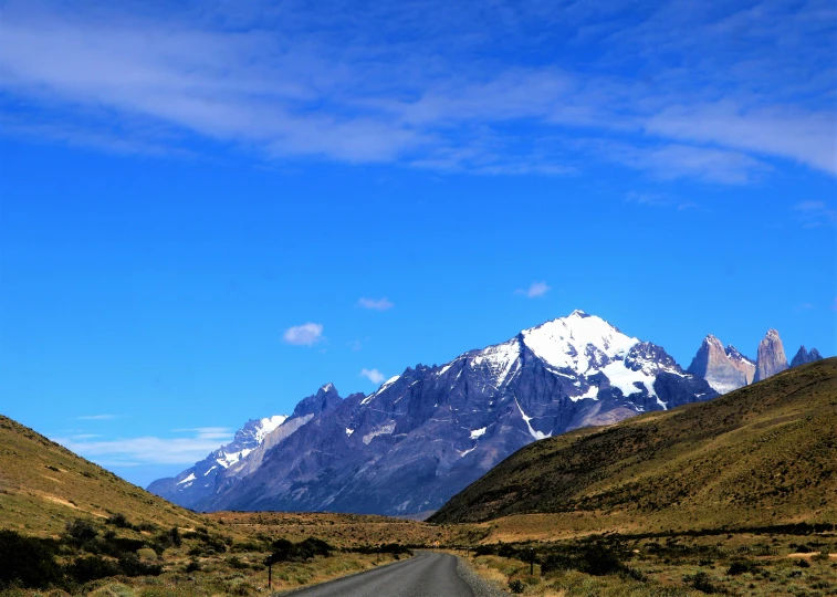 a road near the mountains in the sun