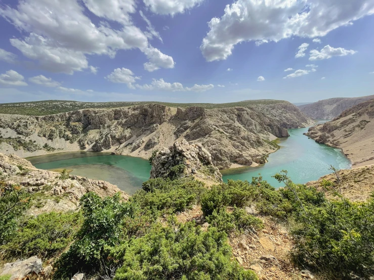 a lake surrounded by greenery in a cliff