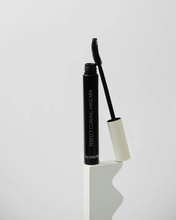 a mascara with a stick of dark brown colored mascara