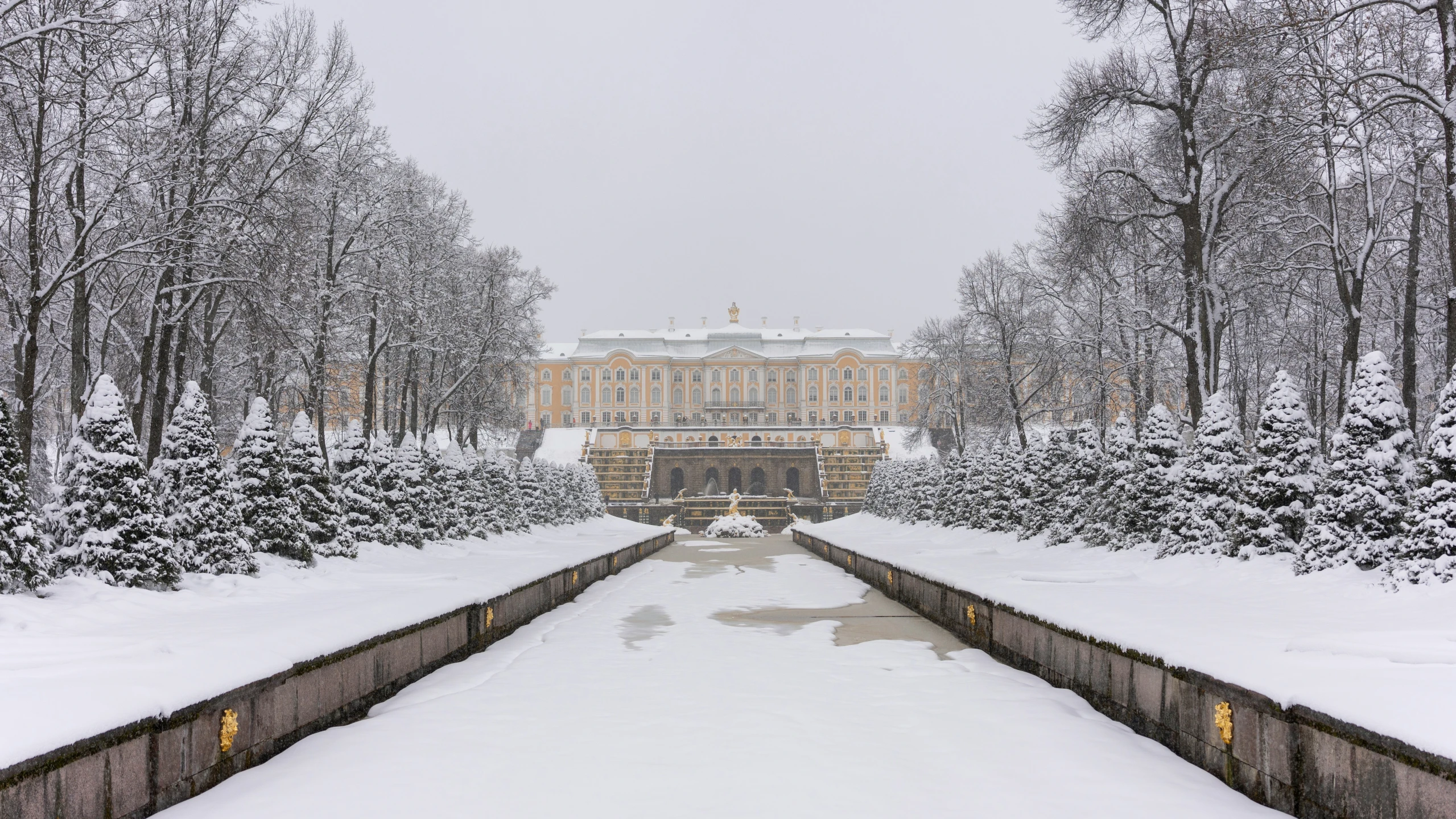 a snow covered pond with a large building in the background