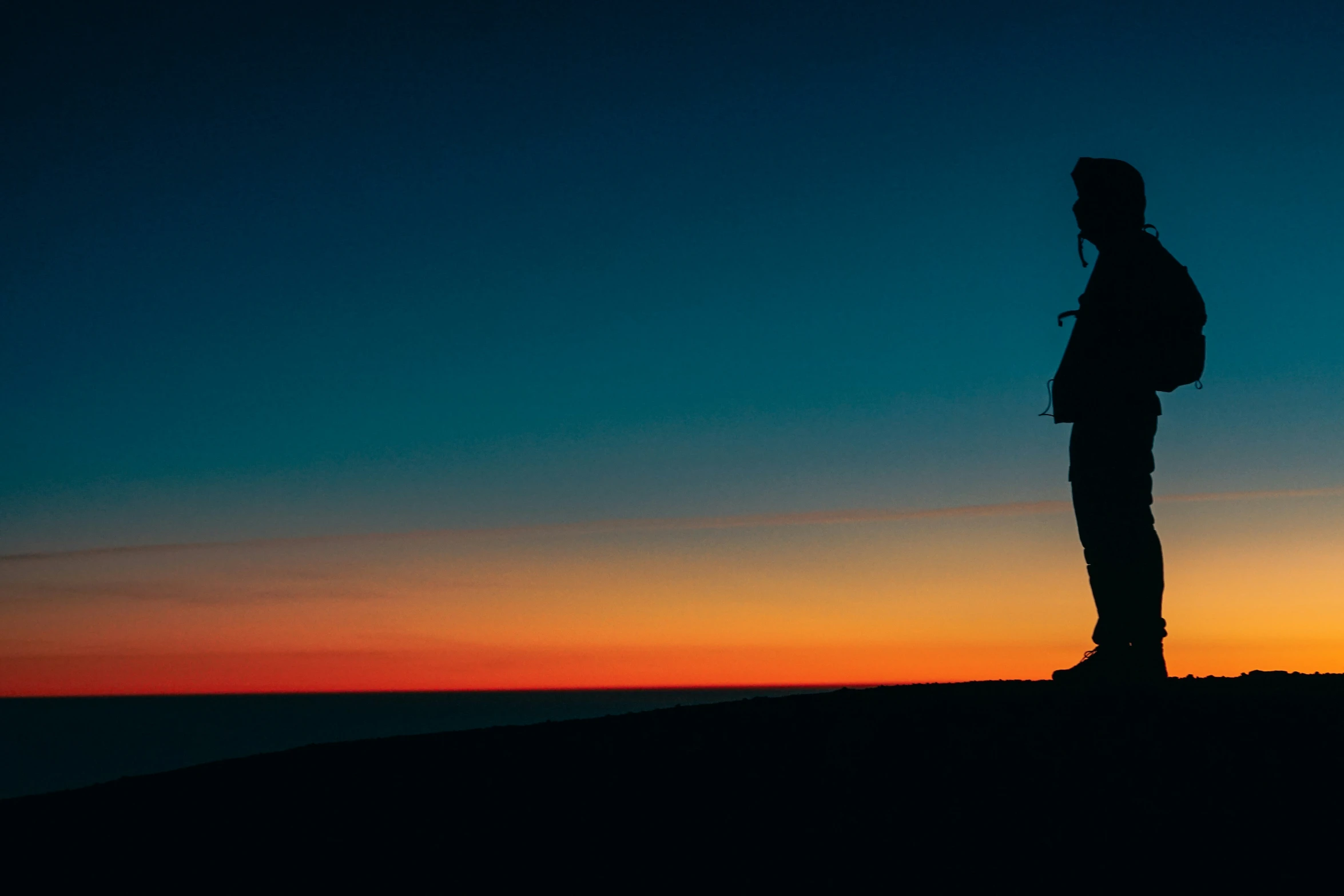 a person standing on top of a hill at sunset