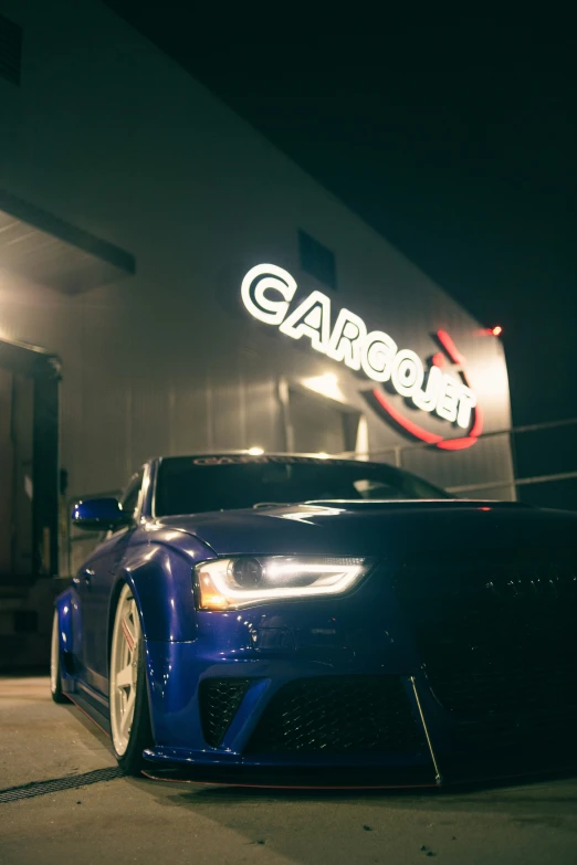 a blue car parked in front of a car shop