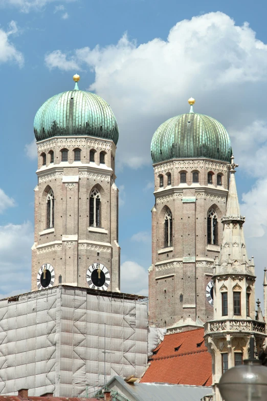 two towers with clock faces sit above buildings