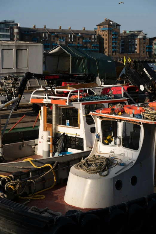 several docked boats sit on the dock near other buildings