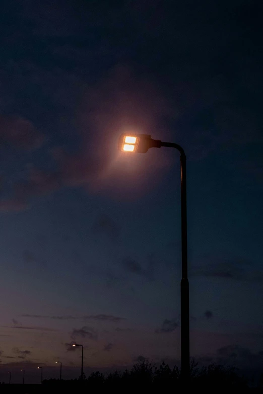an outdoor lamp post with street lights at night