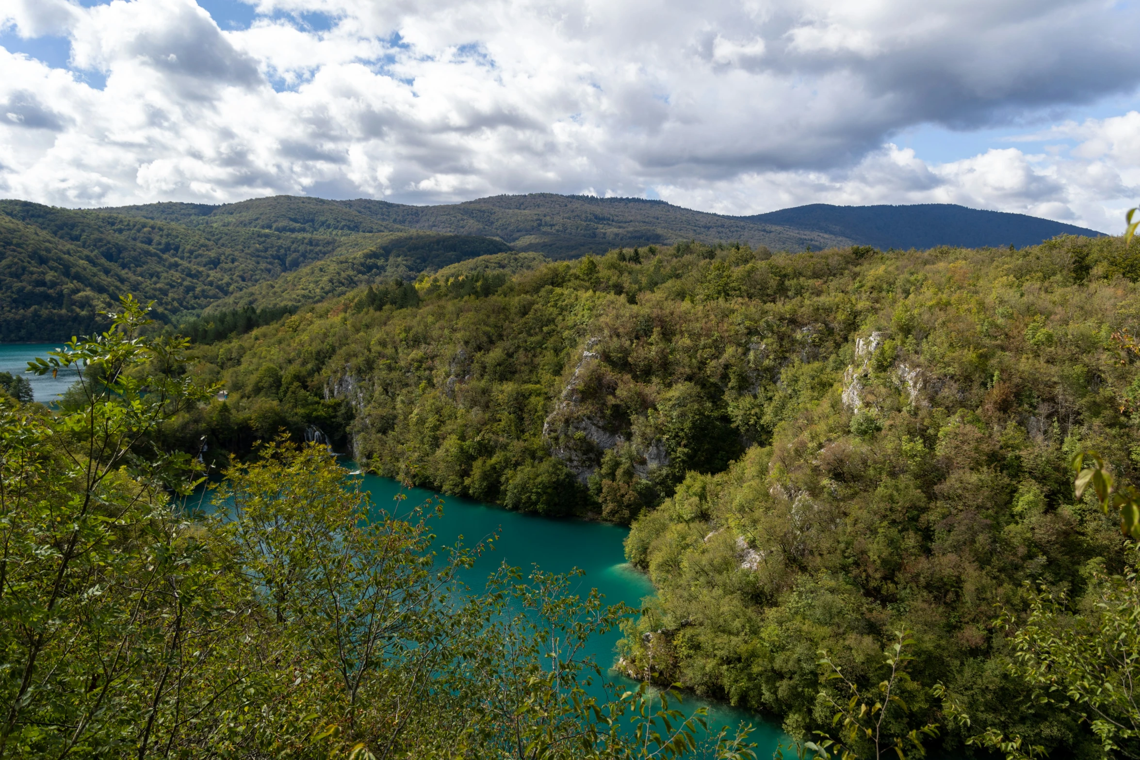 a river in the middle of an area of trees and hills