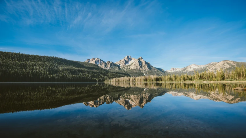 a beautiful mountain scene reflecting the sky on a lake