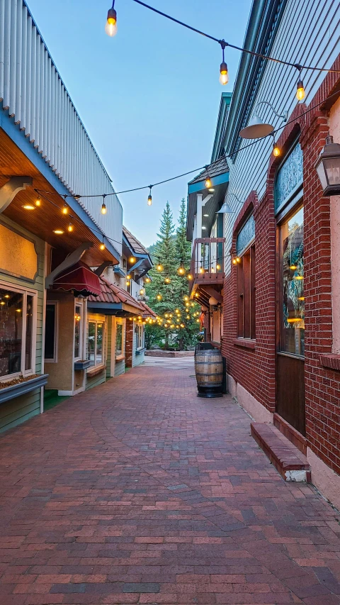 an empty city street is lit with warm lights