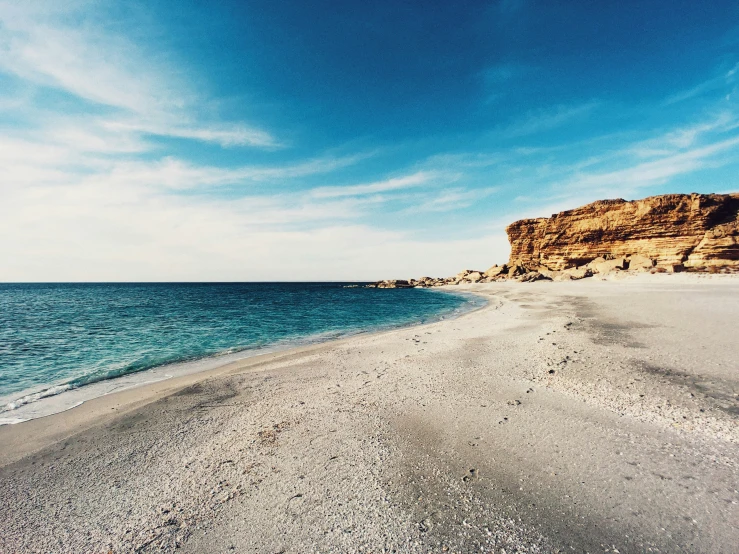 a long sandy beach leading out into the ocean