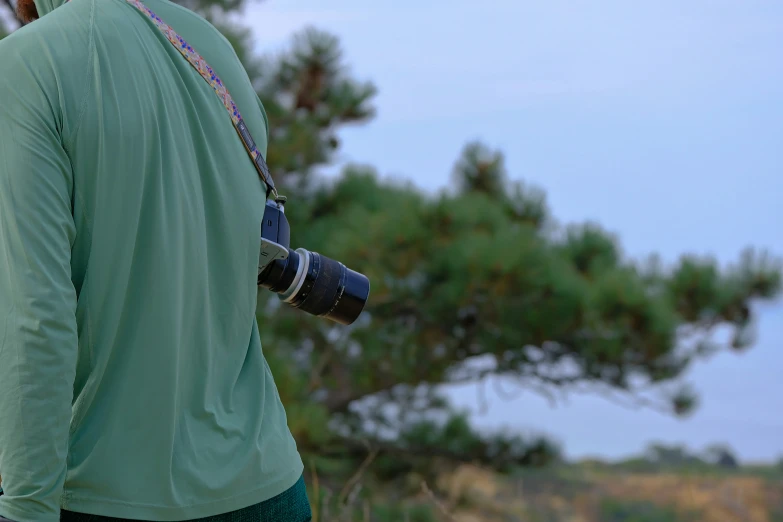 a person with a camera standing by some trees