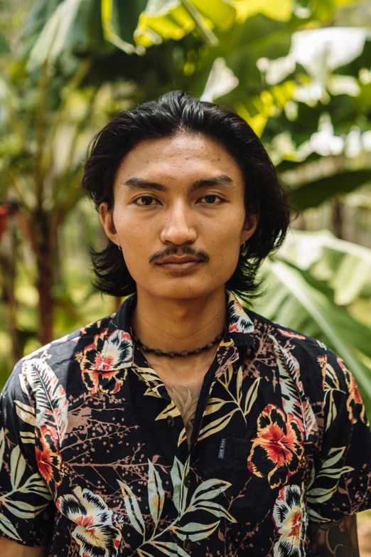 a man with a mustache in a flowery shirt