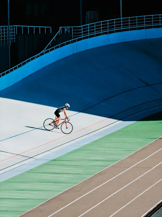 cyclist on track near a sports field at night