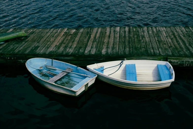 two small boats sit next to a dock