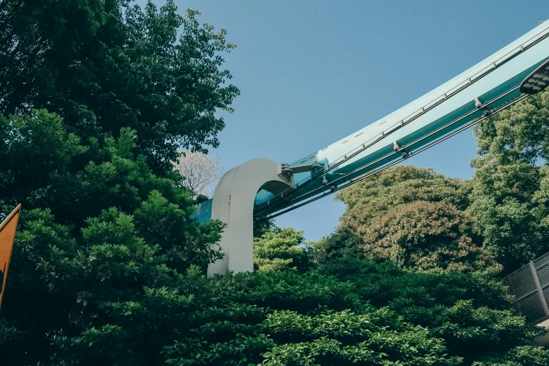 the monorail train is crossing the trees and over a bridge