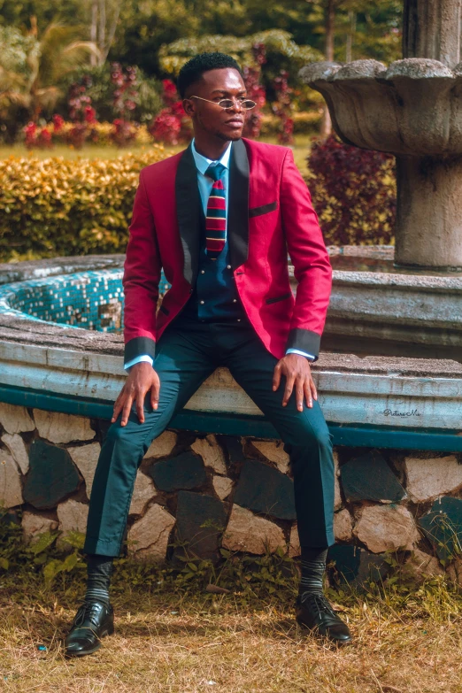 a man sitting on top of a stone fountain