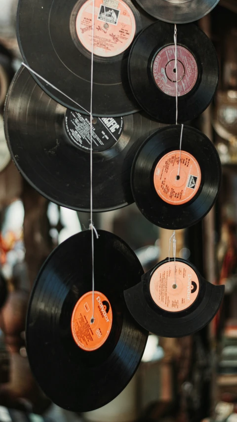 some old vinyl records hang up from strings