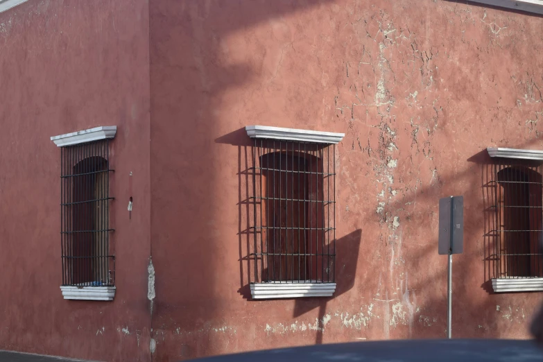 a building with two windows that have bars on them