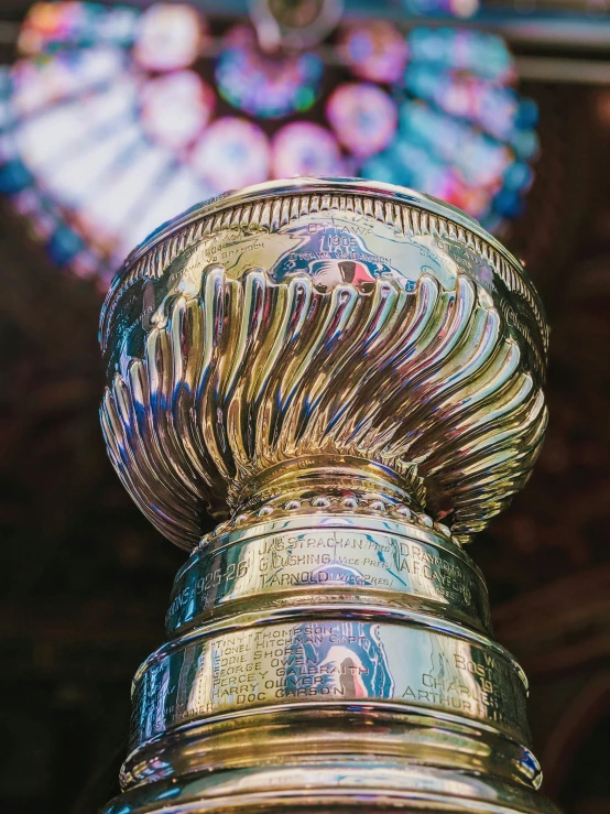 a small golden trophy with a glass stain behind it