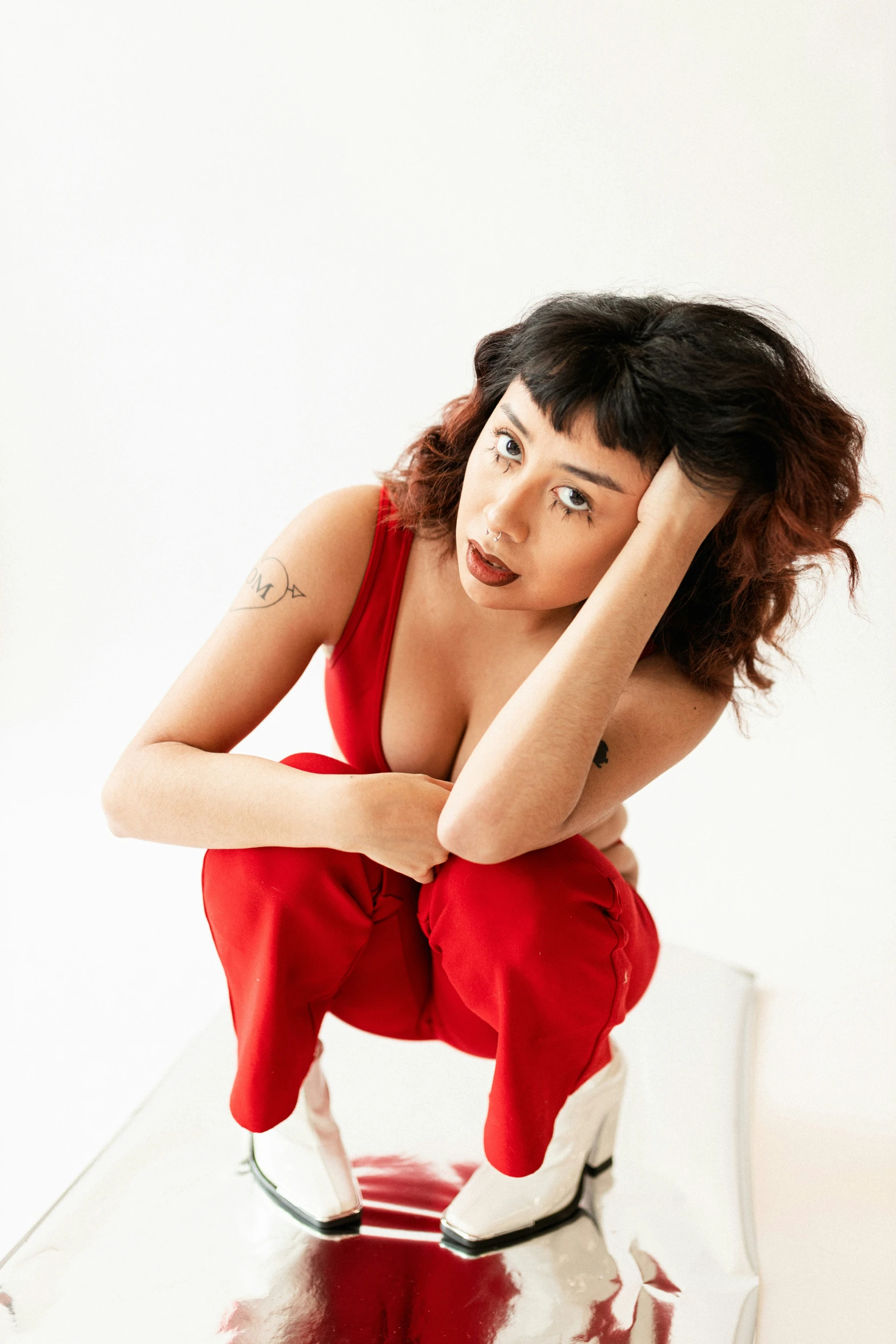 a woman in a red dress sitting on a mirror