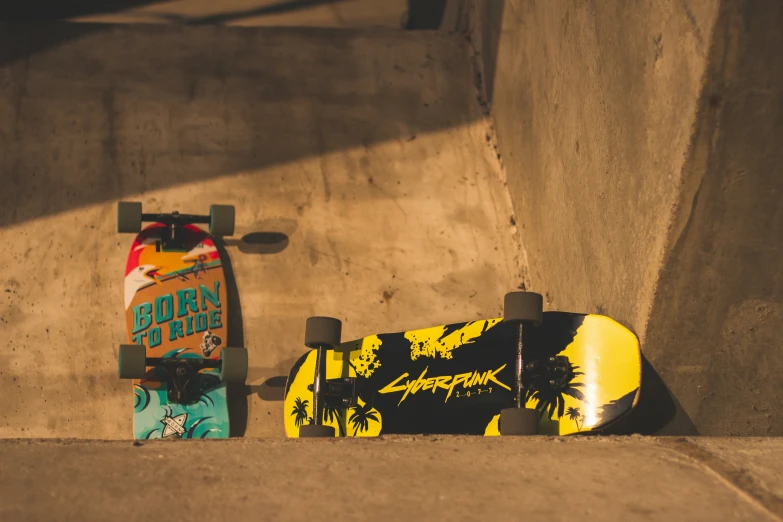 a skateboard and an odd shaped skateboard are in a concrete wall