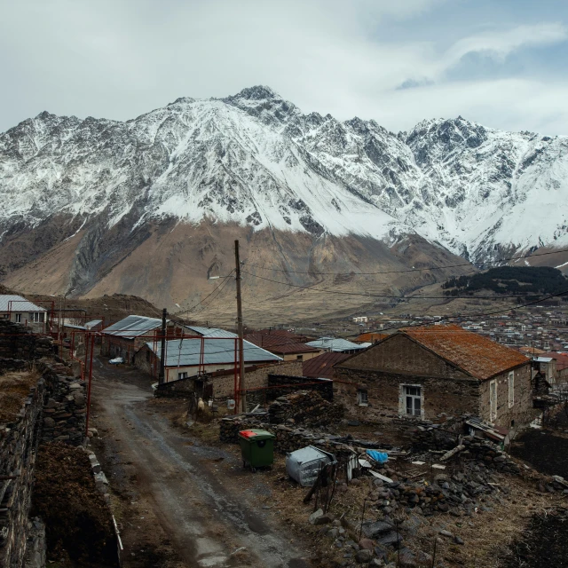 an abandoned village with a view of the snowy mountains