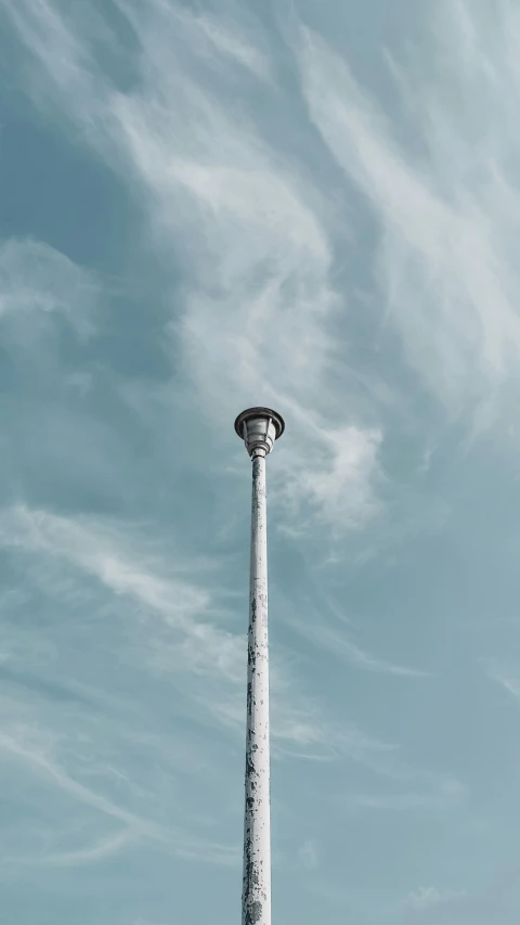 a tall white light house sitting underneath a blue sky