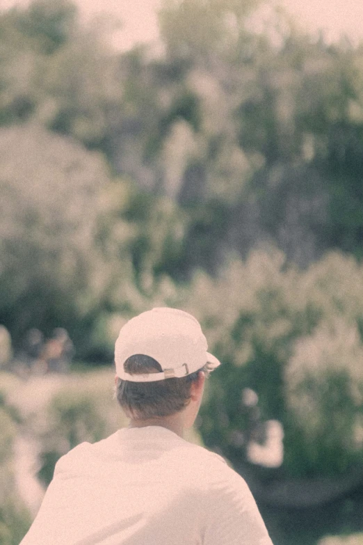 a person wearing a white hat stands with their arm around a boy