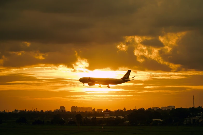 an airplane is flying over the skyline at sunset