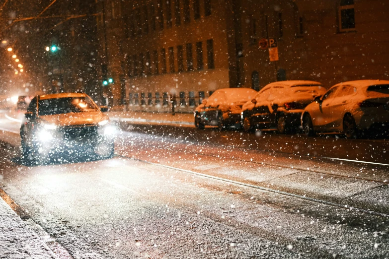 a snow covered street with cars and buildings