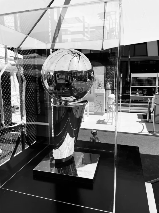 a metal sphere with a wire fence and gate in the background