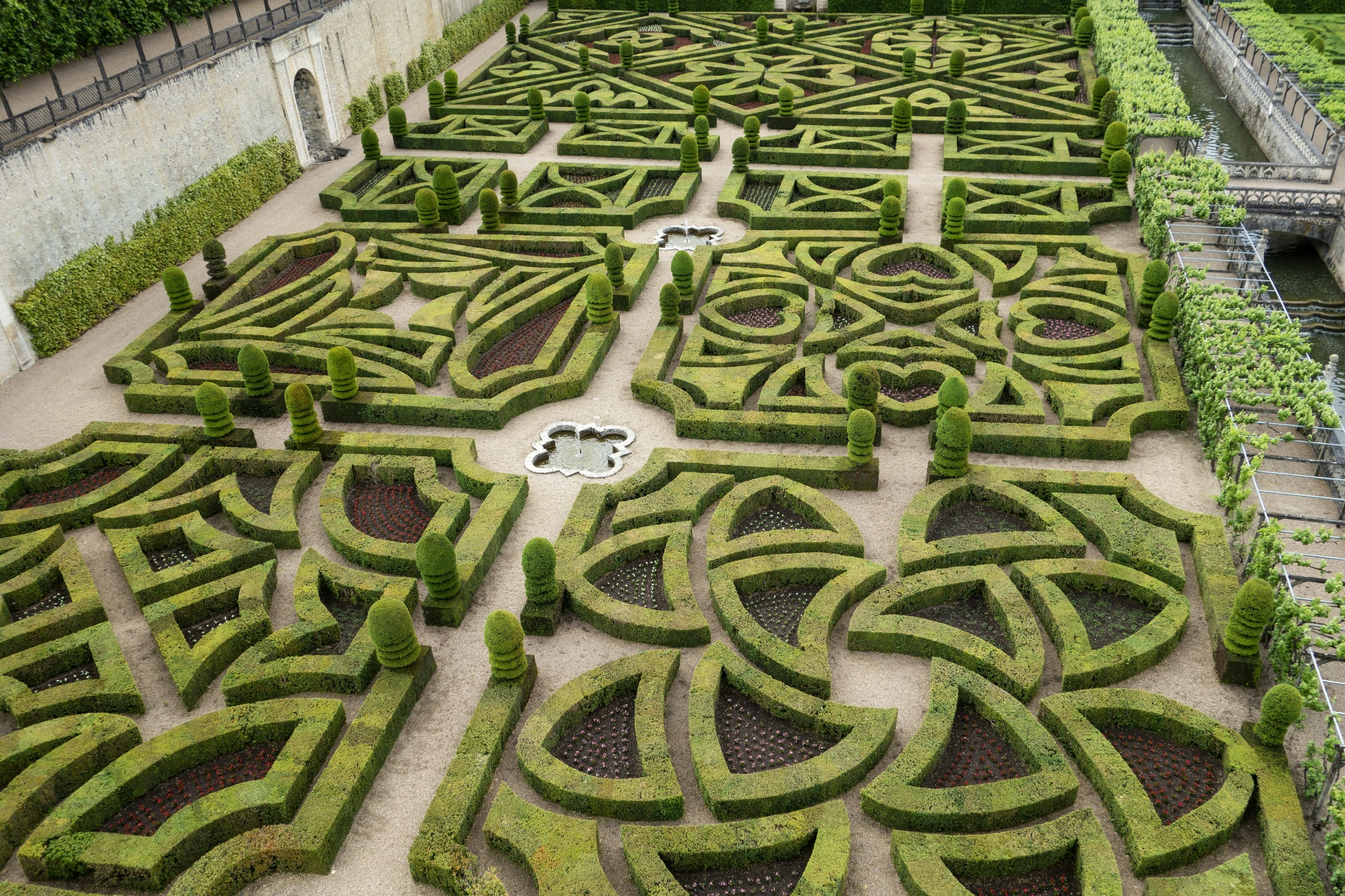a large square maze in the middle of a park with lots of greenery on both sides