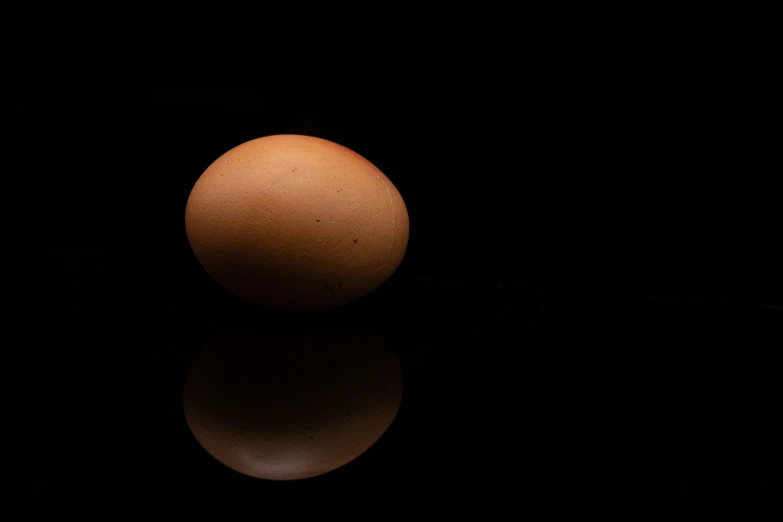 an egg is sitting on a black surface