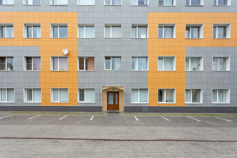 a yellow and gray building with white windows