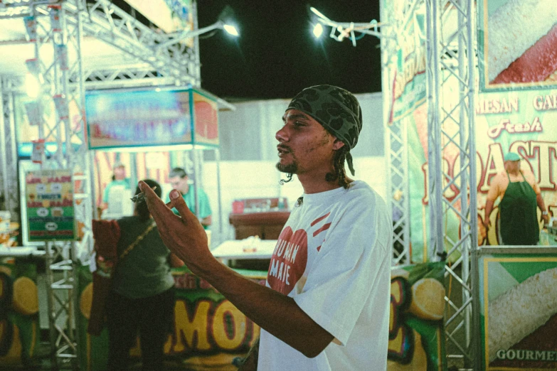 a young man is standing near a booth holding soing