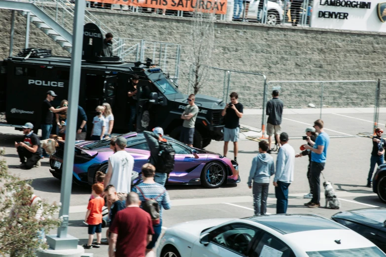 a group of people standing around parked cars