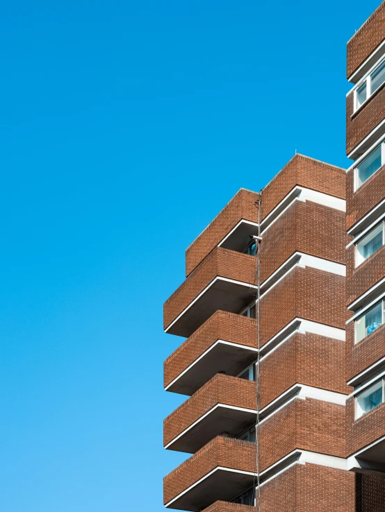 a tall building has many balconies on top