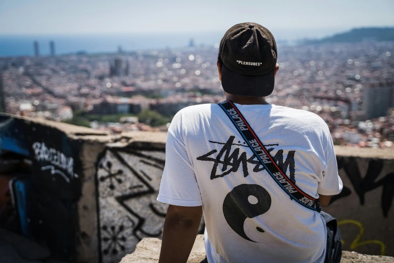 a man in a white shirt standing at the top of a wall