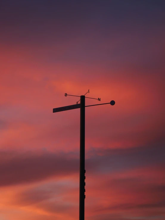 a light pole with the sky behind it at sunset