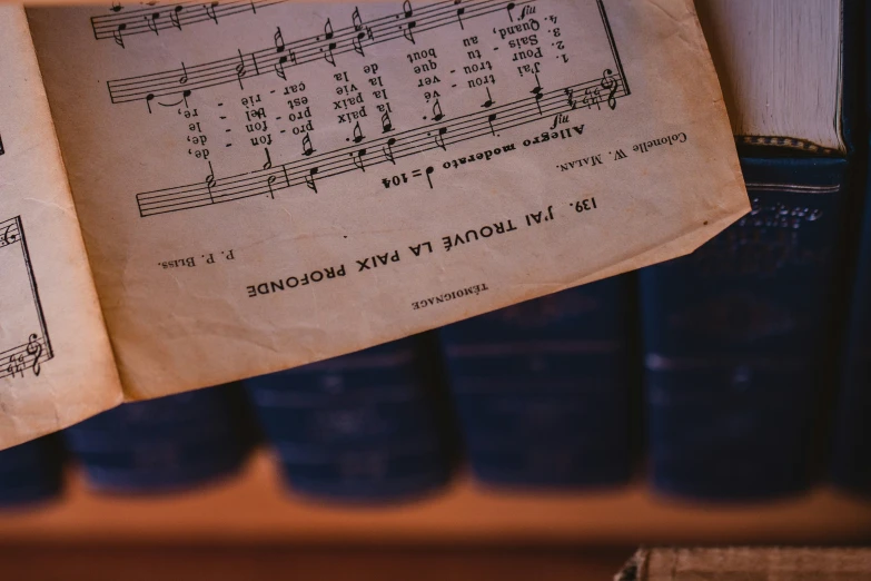 an old song book is open and sitting on a shelf