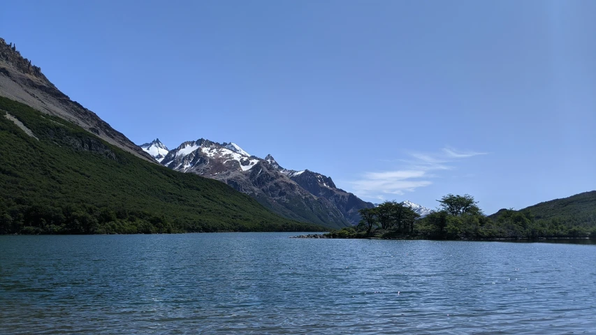 blue water and mountains with white peaks under a clear blue sky