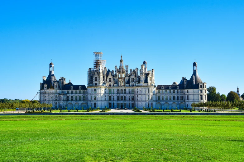 a large mansion with towers in a park