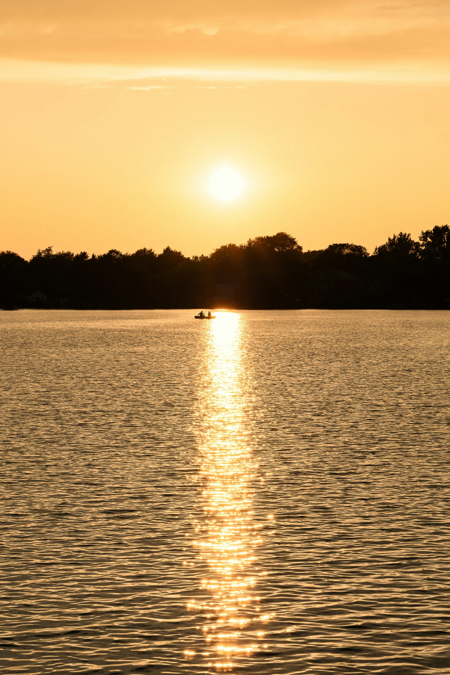 a boat is floating on the water at sunrise