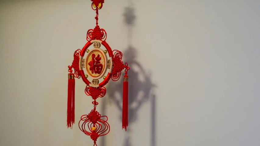 a red and gold clock with hanging bells