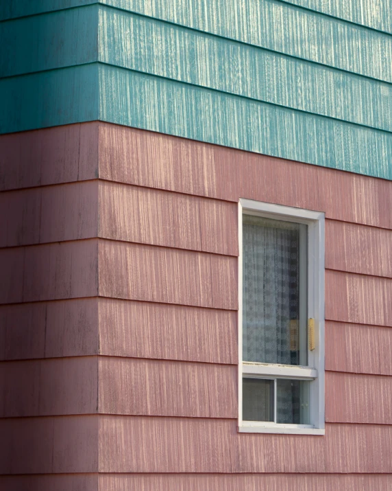 the back of an pink house with a window