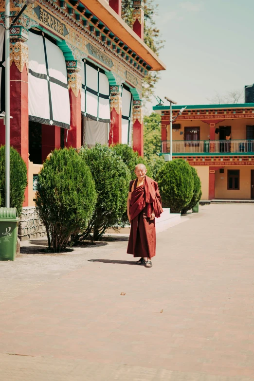 a woman walking in a courtyard on a sunny day