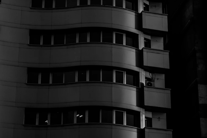 a dark po of a tall building with lots of windows