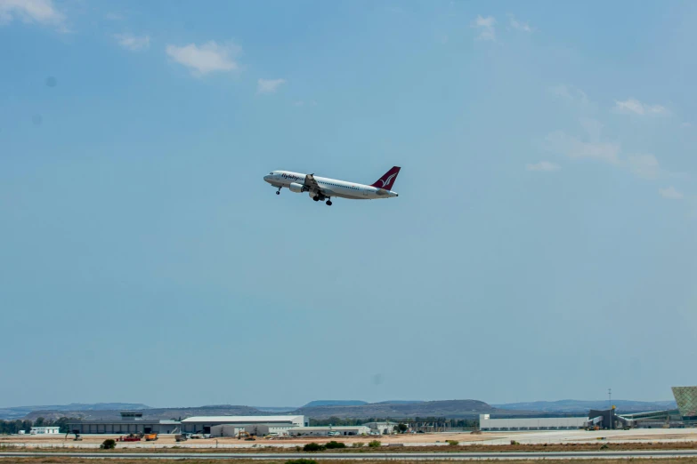 an airplane is flying over some small buildings