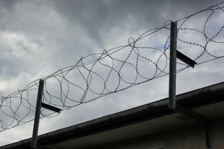 the metal wire and wire fence are next to a building